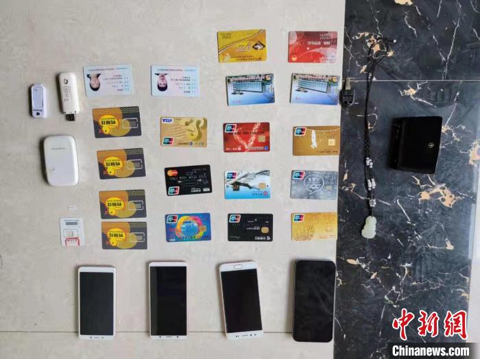 资料图为果洛藏族自治州公安民警查扣的作案手机和涉案银行卡。　玛沁县公安局供图